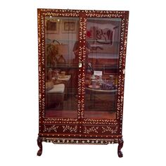 an ornately decorated china cabinet with glass doors