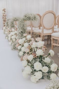 a row of chairs sitting next to each other with flowers on the back of them