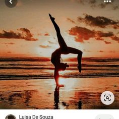 a woman doing a handstand on the beach at sunset