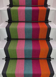 colorful striped carpeted stairs with black railings