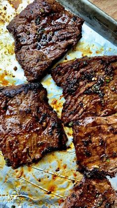 four steaks on a baking sheet ready to be grilled in the oven,