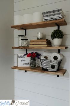 two shelves with candles, books and flowers on them in the corner of a room