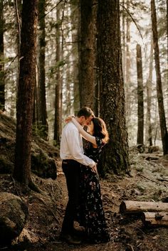 a man and woman are standing in the woods