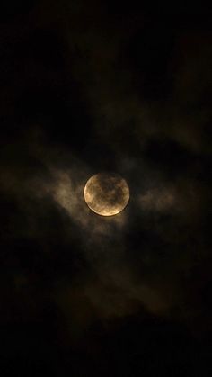 the moon is shining brightly in the night sky with clouds around it and dark skies