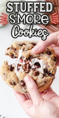 someone holding up a cookie with white frosting on top and chocolate chips in the middle