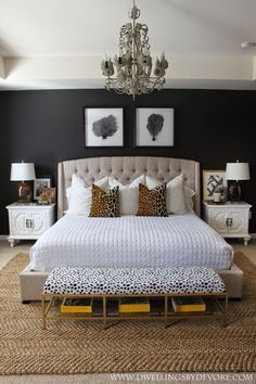 a bedroom with black walls, white bedding and leopard print on the foot board