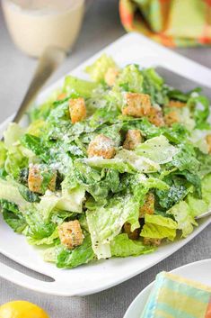 a salad with croutons and parmesan cheese is on a white plate