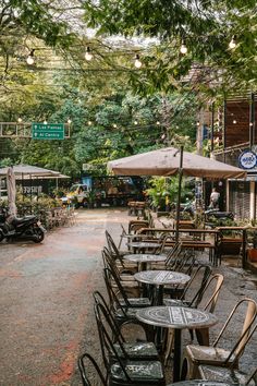 tables and chairs are lined up outside under umbrellas