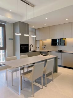 a modern kitchen with an island table and chairs