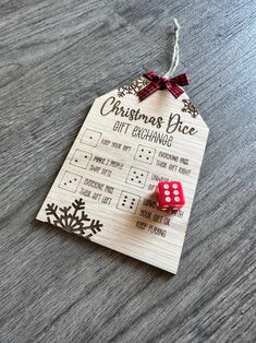 a wooden christmas ornament with two red dices on it and the words, christmas