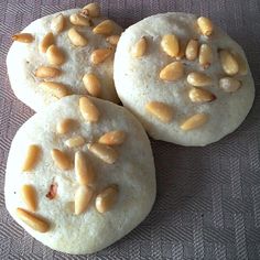 three cookies with nuts on them sitting on a table