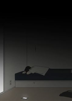 a person laying on a bed in a dark room