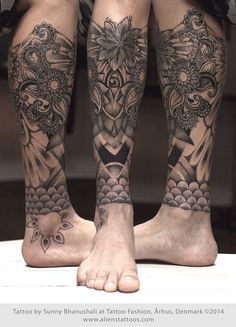 the legs and ankles of a man with tattoos on them