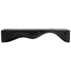 a wooden shelf with black wood on it's sides and two holes in the top