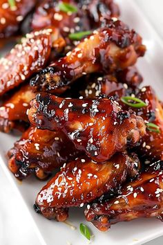 chicken wings covered in sesame seeds on a white plate