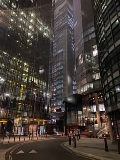 an empty city street at night with skyscrapers in the background