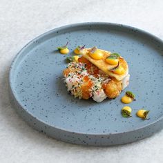 a blue plate topped with food on top of a white tablecloth covered flooring