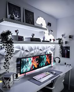 a desk with a computer monitor and keyboard on top of it next to a potted plant