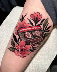 a tattoo with an old school style cassette and flowers on the arm that reads, i love you all