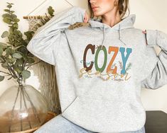 Cozy Season Sweatshirt, Cozy Season Tee, Retro Fall Sweatshirt, Get Cozy Sweatshirt, Womens Fall Sweater, Fall Graphic Tee, Women Fall Shirt Welcome to  Rose Tee US! We are very proud to say that our T-Shirts are made with the leading brand in blanks, Bella Canvas! They are super soft, comfortable, have great color vibrancy and are made in the US. Cozy Season Hoodies, Retro Halloween Nurse, Fall Spooky Nurse, Ghost Nurse Halloween Sweatshirt, Fall Vibes Sweater, Fall Halloween Hoodie CARE INSTRUCTUONS All our designs are made with DTF. So, please: *Wash Inside Out *Use Warm/cold Water *DO NOT Use Bleach *DO NOT Dry Clean *DO NOT Iron Directly Onto The Image On Your Shirt DESIGN/TEXT COLORS We use Black text color/design for; White, Athletic Heather, Yellow, Orange, Pink, Baby Blue, Mint, N Cozy Winter T-shirt For Loungewear, Trendy Winter Loungewear T-shirt, Cozy Winter T-shirt With Relaxed Fit, Cozy Relaxed Fit Winter T-shirt, Cozy Heather Grey Cotton Tops, Cute Winter T-shirt For Loungewear, Comfy Tops With Letter Print, Graphic Tee Women, Fall Graphic Tee