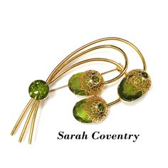 "*Description: This is a beautiful Sarah Coventry brooch entitled \"Touch of Elegance\" which has three green Austrian crystal faceted oval stones with gold tone filigree flower tops from the 1970s. Each flower top has a green rhinestone chaton with a larger green rhinestone chaton placed on the stems. This brooch is a book piece and is found on page 100 of Sarah Coventry Jewelry by Kay Oshel. The brooch is also featured in The Art of Juliana Jewelry by Katerina Musetti. This would be a great ad Antique Green Brooch For Anniversary, Antique Green Brooches For Anniversary, Mid-century Green Brooch For Formal Occasions, Mid-century Green Brooches For Formal Occasions, Green Mid-century Style Brooches For Formal Occasions, Mid-century Green Formal Brooches, Mid-century Green Brooch As A Gift, Juliana Jewelry, Formal Earrings