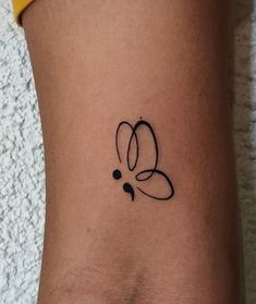 a small tattoo on the side of a woman's leg, with an abstract design