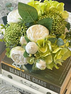 a bouquet of flowers sitting on top of a stack of books next to each other