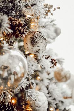 a white christmas tree with silver and gold ornaments