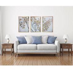 a living room with two paintings on the wall and a couch in front of it