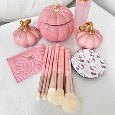 the contents of a pink pumpkin makeup set on a white surface with other items around it