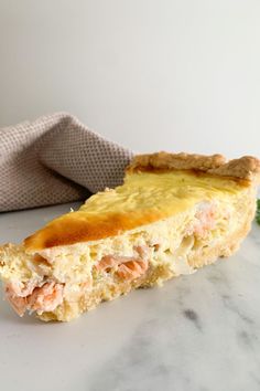 a close up of a piece of food on a table next to a cloth napkin