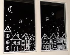 two windows decorated with white paper houses and stars in the night sky, each window is drawn by hand