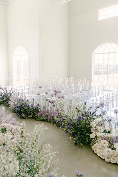 rows of chairs with flowers on the floor in front of them at a wedding ceremony