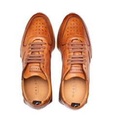 Style 21135-Cognac Modern, Designer slip-on Sneaker from the Mezlan collection in Soft, Supple Deerskin features Perforated Detailing, their Injected Memory Foam Comfort Cushion insole, and a Rugged Rubber Sneaker Sole! Handmade in Spain. Classic Brown Business Sneakers, Designer Brown Sneakers With Leather Lining, Luxury Business Slip-on Sneakers, Luxury Cognac Leather Shoes With Plain Toe, Elegant Brown Sneakers With Textured Sole, Brown Leather Lined Sneakers For Business, Luxury Brown Leather Shoes With Textured Sole, Luxury Cognac Leather Shoes With Branded Insole, Luxury Cognac Leather Shoes With Round Toe