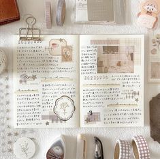 an open book surrounded by various items on top of a white surface with japanese writing