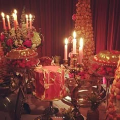 a table topped with lots of different types of cakes and desserts covered in candles