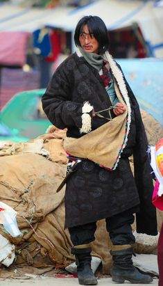 a woman standing next to a pile of bags