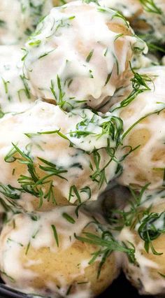 some food is piled on top of each other in a black bowl and garnished with green herbs