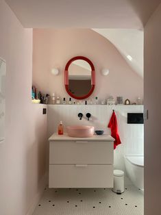 a bathroom with a sink, mirror and toilet in the corner next to a bathtub