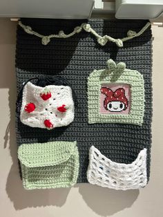 there is a crocheted bag hanging on the wall with other items attached to it