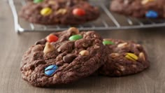 chocolate cookies with m & m's and candy on top are cooling on a rack