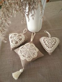 three decorative pillows are sitting on a table next to a vase with flowers in it