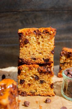 three pieces of cake sitting on top of a piece of parchment paper next to a bowl of chocolate chips