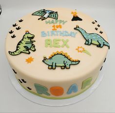 a birthday cake decorated with dinosaurs and stars