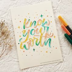 a card with the words know your worth written on it next to some pens and flowers