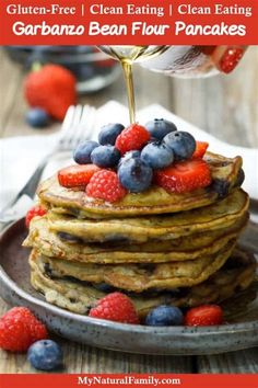 a stack of pancakes with berries and syrup being drizzled on top for garbanzo bean flour pancakes