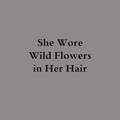 the words she wore wild flowers in her hair are black and white on a gray background