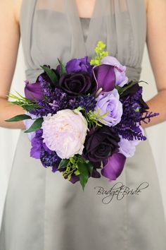 a bridesmaid holding a purple and white bouquet with flowers in her lapel