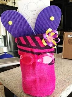 a pink and purple hat with sunglasses on top of a counter next to a cardboard box