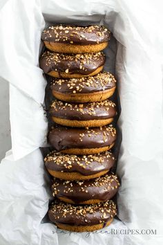 Vegan donuts frosted with a chocolate glaze and crunchy almonds, placed in a loaf pan lined with parchment paper. Vegan Gluten Free Donuts, Vegan Chocolate Frosting, Healthy Donuts, Glazed Donuts, Chocolate Glazed Donuts, Vegan Donuts, Gluten Free Donuts, Gluten Free Recipes Bread, Homemade Donuts